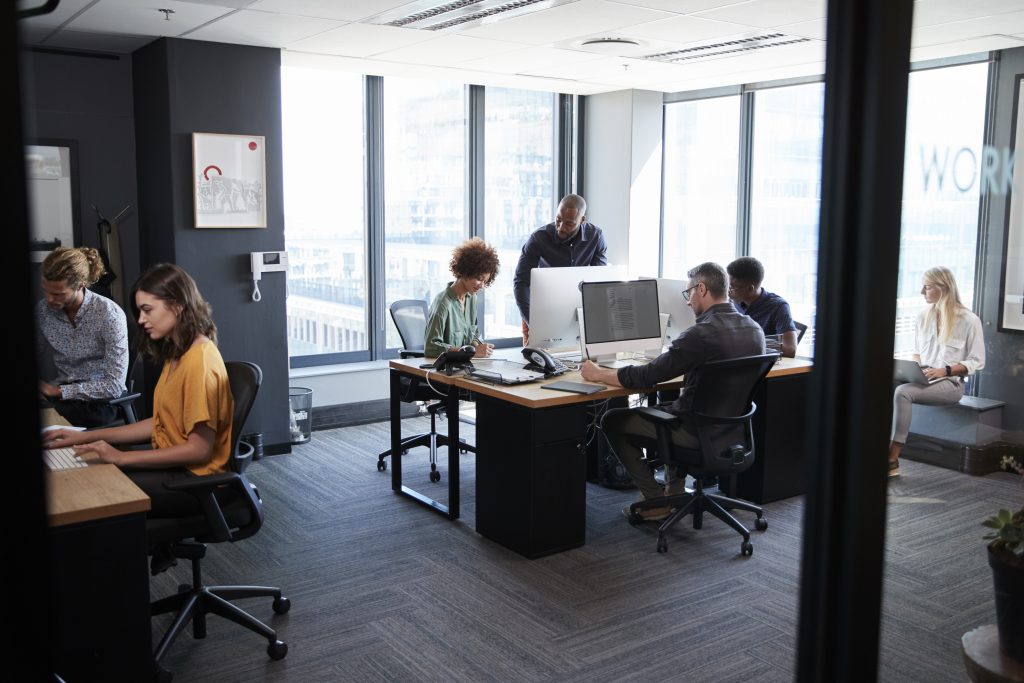 Employees working in a bustling office environment, showcasing the need for Southeast Office Products' supplies and solutions.